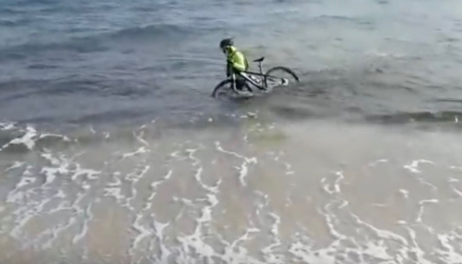 Covid-19: per evitare la multa, un ciclista entra in mare (Video)