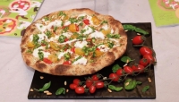 la pizza &#039;profumi liguri&#039; con cuore di burrata, pomodorino datterino, pomodorino giallo, pesto a mortaio, pinoli tostati e parmigiano